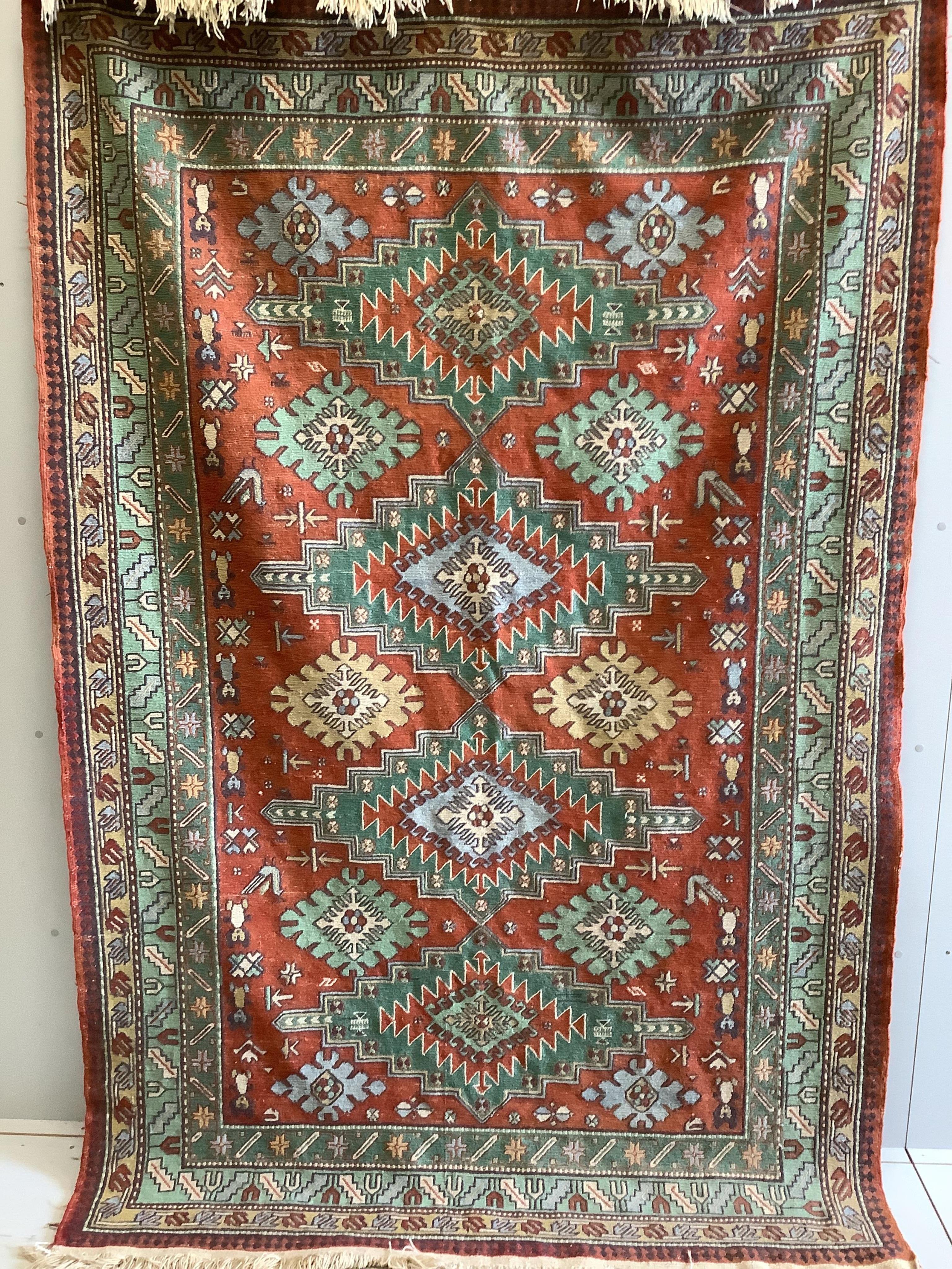 A Caucasian style polychrome red ground carpet, 244 x 160cm. Condition - fair